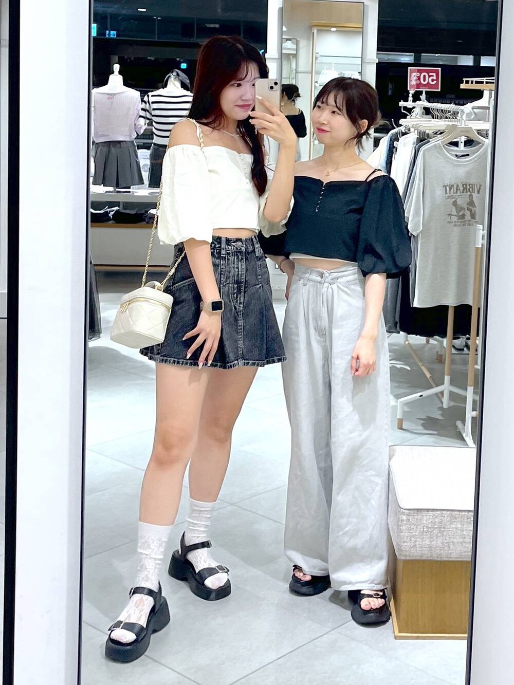 ブラック系のデニムスカート、ブラック系のサンダル、ホワイト系のショルダーバッグを着用したレディースの夏コーディネートの6枚目の写真