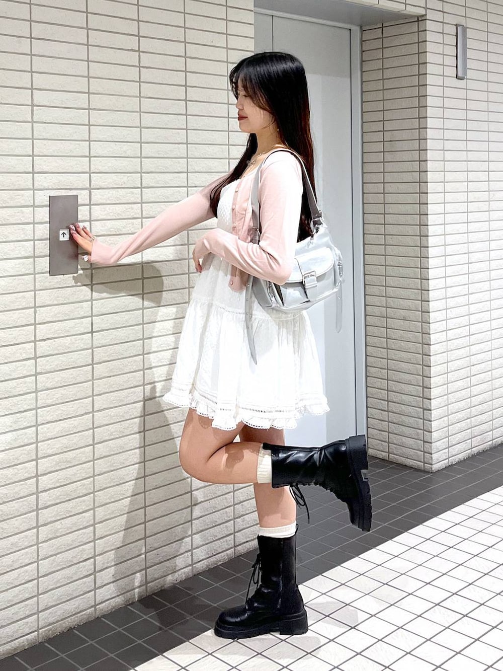 ホワイト系のキャミソール、ピンク系のカーディガン/ボレロ、ブラック系のブーツを着用したレディースの春コーディネートの3枚目の写真