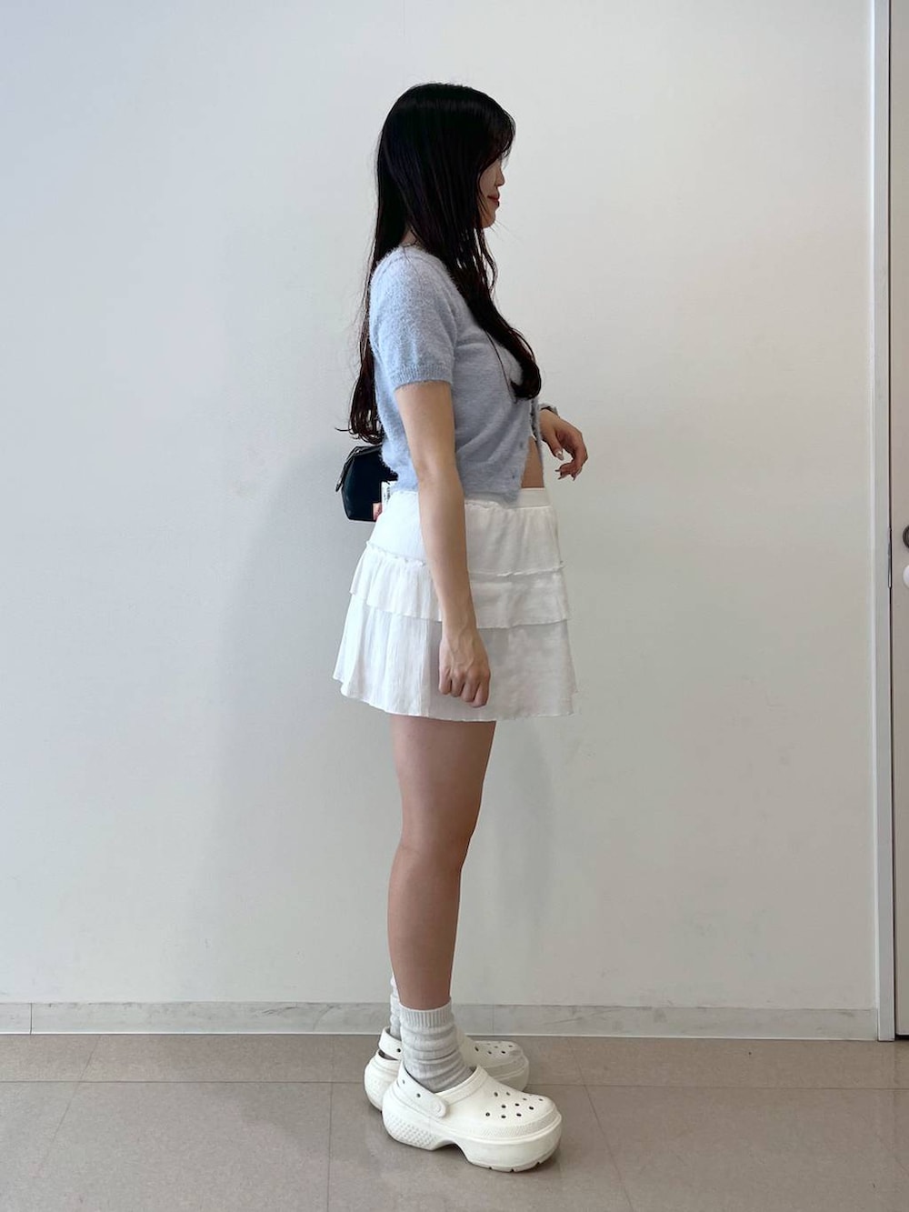 ホワイト系のスカート、ブラック系のボストンバッグ、ホワイト系のキャミソールを着用したレディースの春コーディネートの3枚目の写真