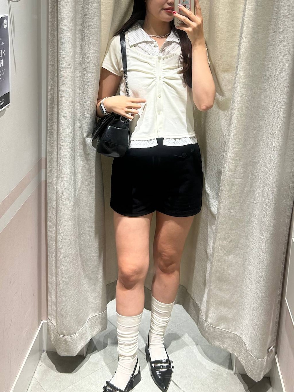 ブラック系のパンプス、ブラック系のショルダーバッグ、ホワイト系のチューブトップを着用したレディースの夏コーディネートの3枚目の写真