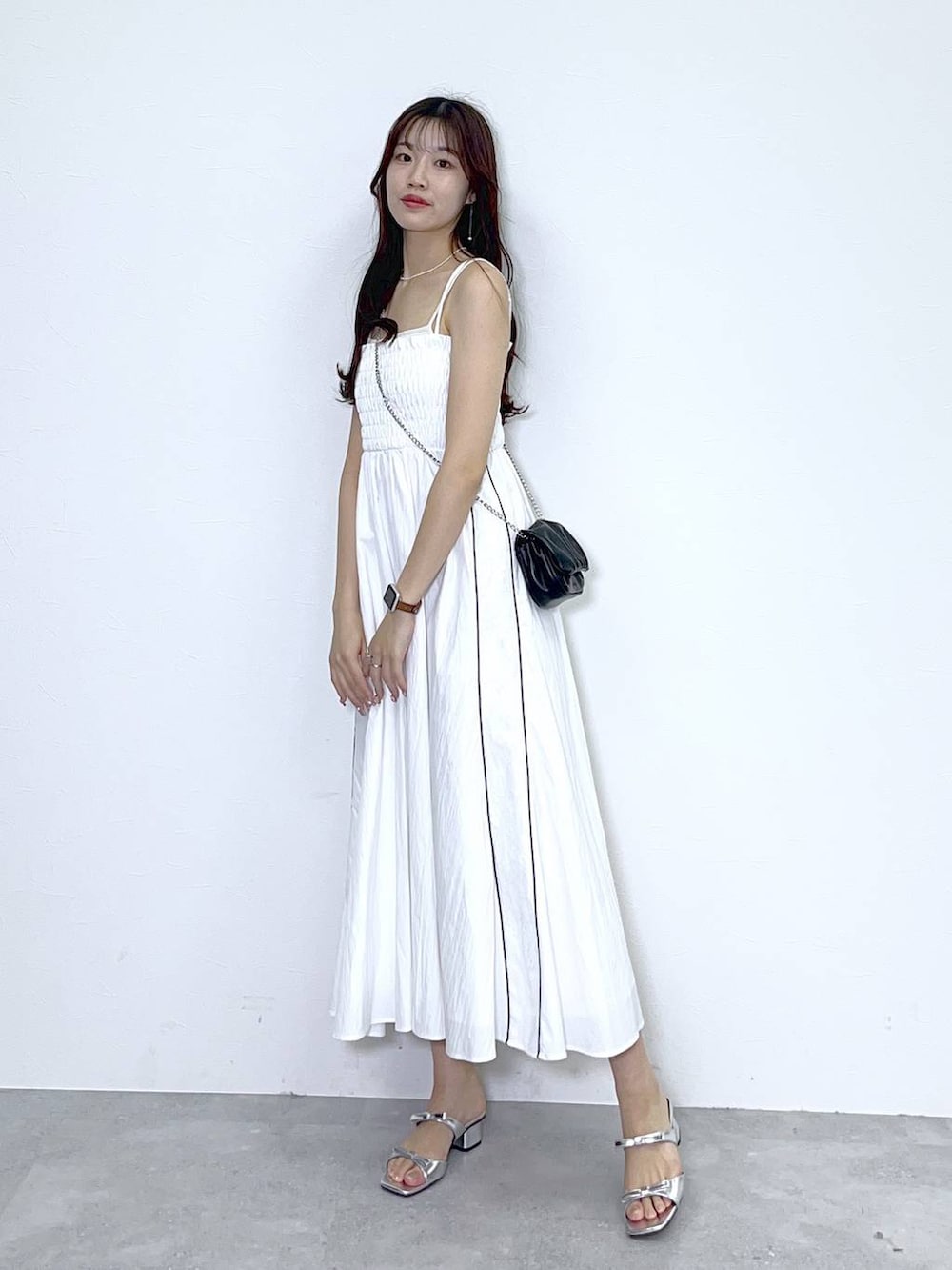 ブラック系のショルダーバッグ、ホワイト系のキャミソール、シルバー系のサンダルを着用したレディースの春コーディネートの5枚目の写真