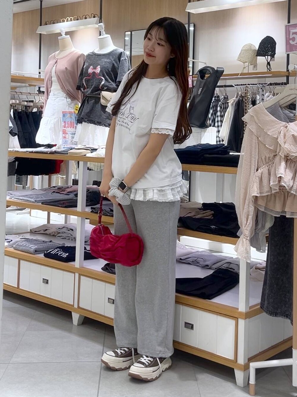 ホワイト系のキャミソール、レッド系のショルダーバッグ、グレー系のスウェットパンツを着用したレディースの春コーディネートの3枚目の写真