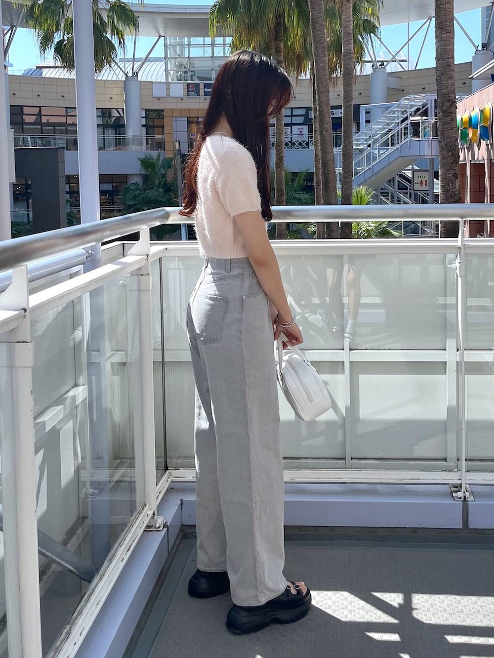 ピンク系のカーディガン/ボレロ、グレー系のデニムパンツ、ホワイト系のキャミソールを着用したレディースの夏コーディネートの4枚目の写真