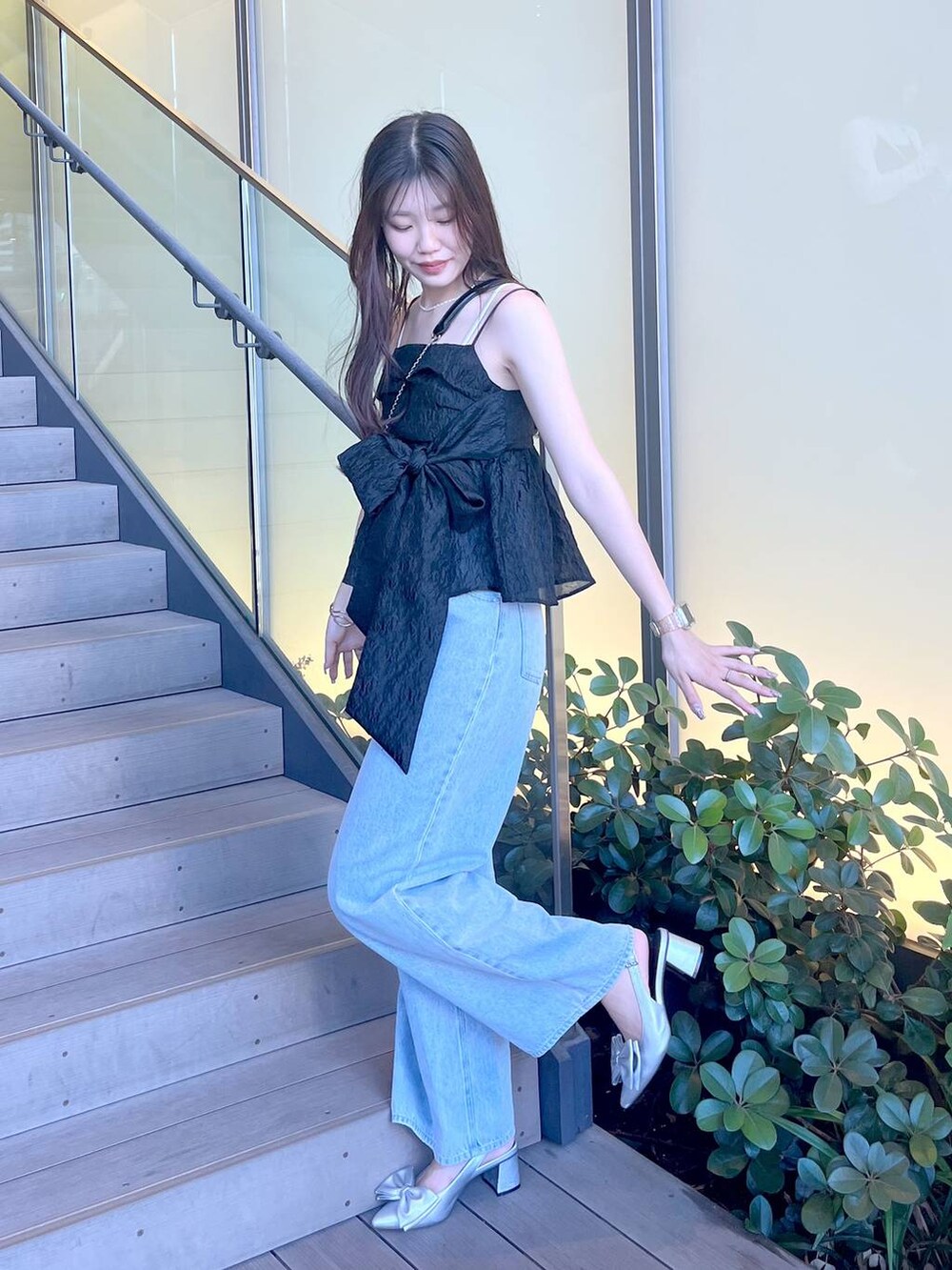 シルバー系のサンダル、ブラック系のショルダーバッグ、ホワイト系のキャミソールを着用したレディースの夏コーディネートの6枚目の写真