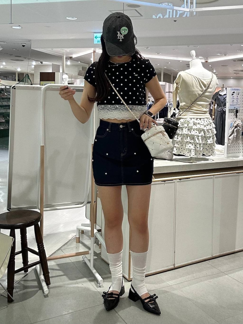 ホワイト系のショルダーバッグ、ブラック系のパンプス、ホワイト系のチューブトップを着用したレディースの夏コーディネートの3枚目の写真