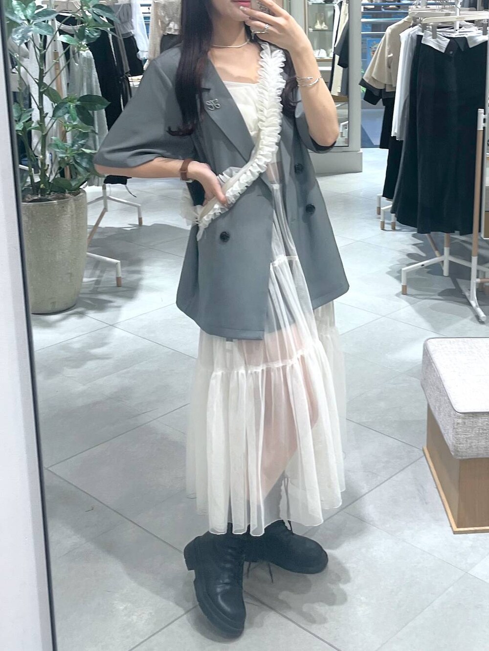 ホワイト系のワンピース、ホワイト系のキャミソール、ブラック系のブーツを着用したレディースの春コーディネートの3枚目の写真