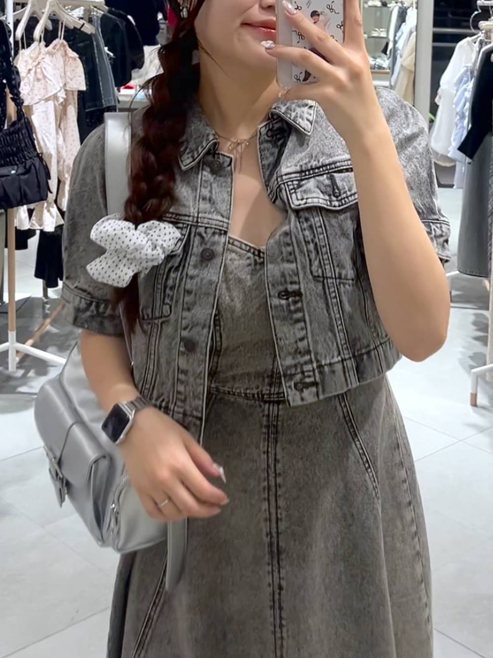 シルバー系のショルダーバッグ、グレー系のデニムジャケット、グレー系のワンピースを着用したレディースの春コーディネートの3枚目の写真