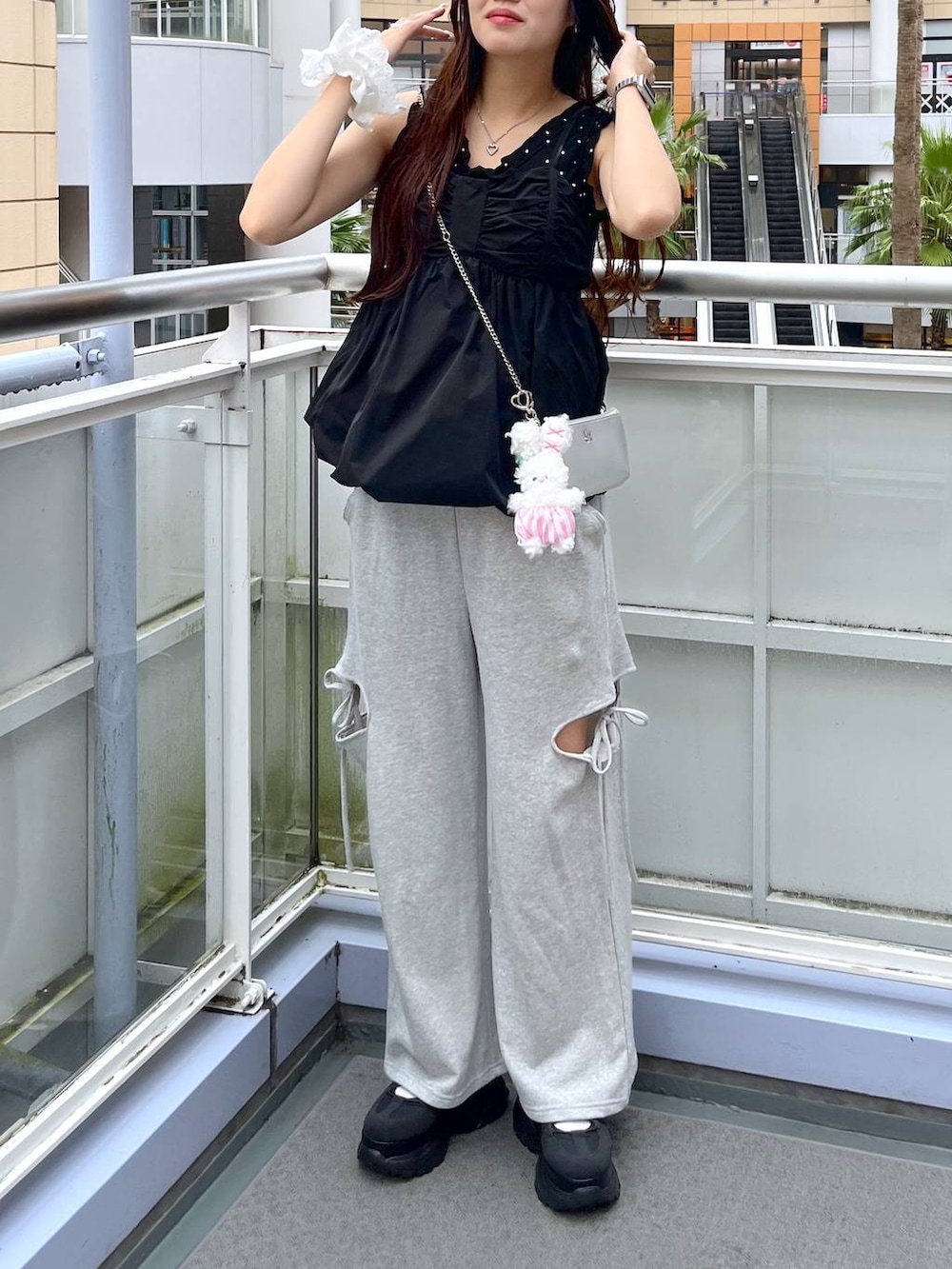 グレー系のスウェットパンツ、ブラック系のシャツ/ブラウス、シルバー系のショルダーバッグを着用したレディースの夏コーディネートの6枚目の写真