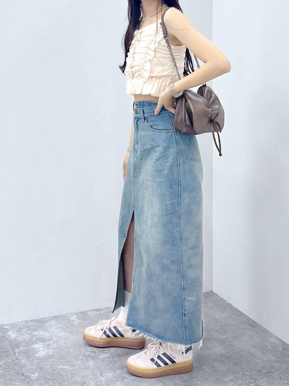ブラウン系のショルダーバッグ、ホワイト系のキャミソール、ブルー系のデニムスカートを着用したレディースの夏コーディネートの6枚目の写真