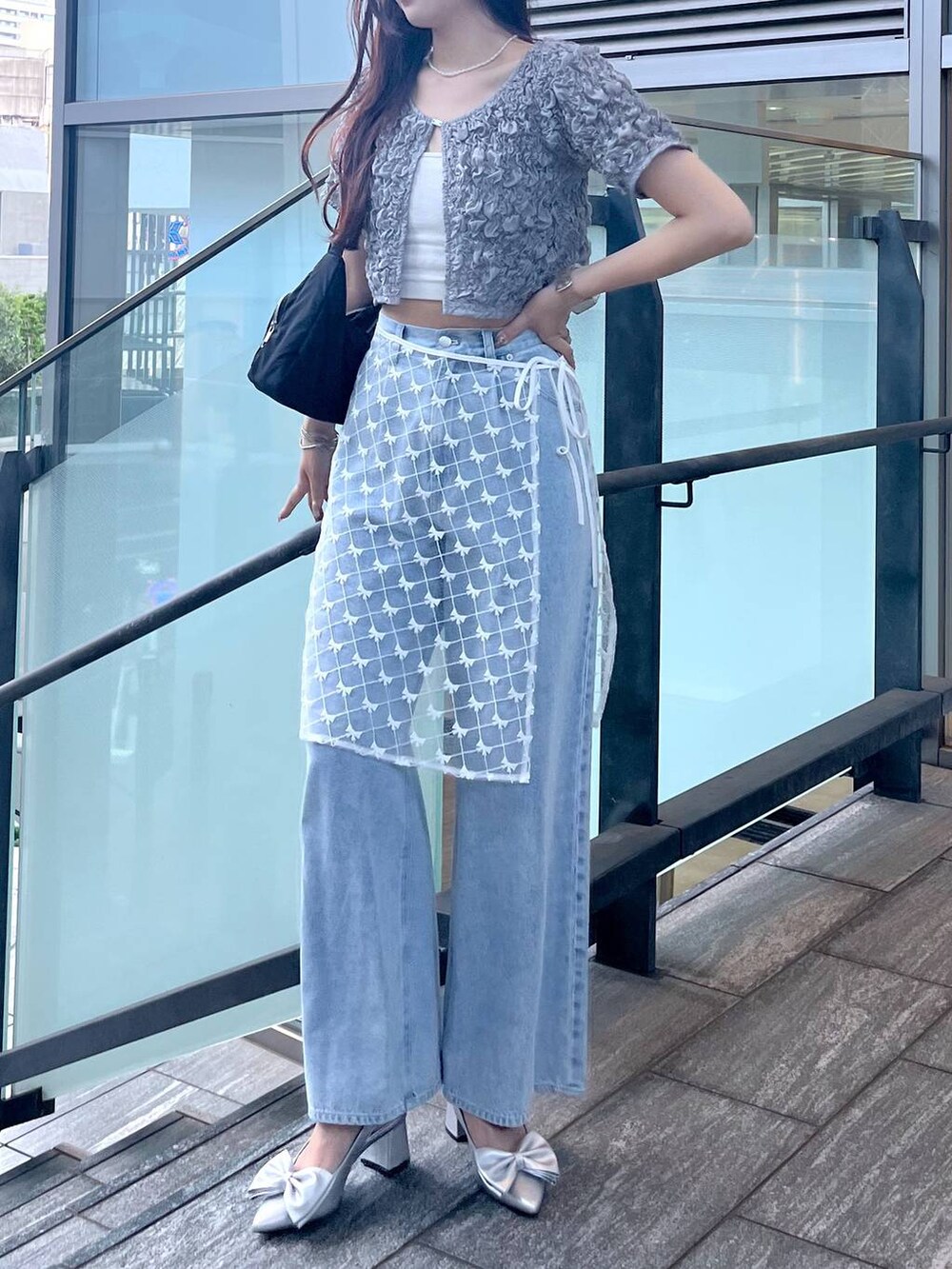 シルバー系のサンダル、ホワイト系のキャミソール、ブルー系のデニムパンツを着用したレディースの夏コーディネートの4枚目の写真