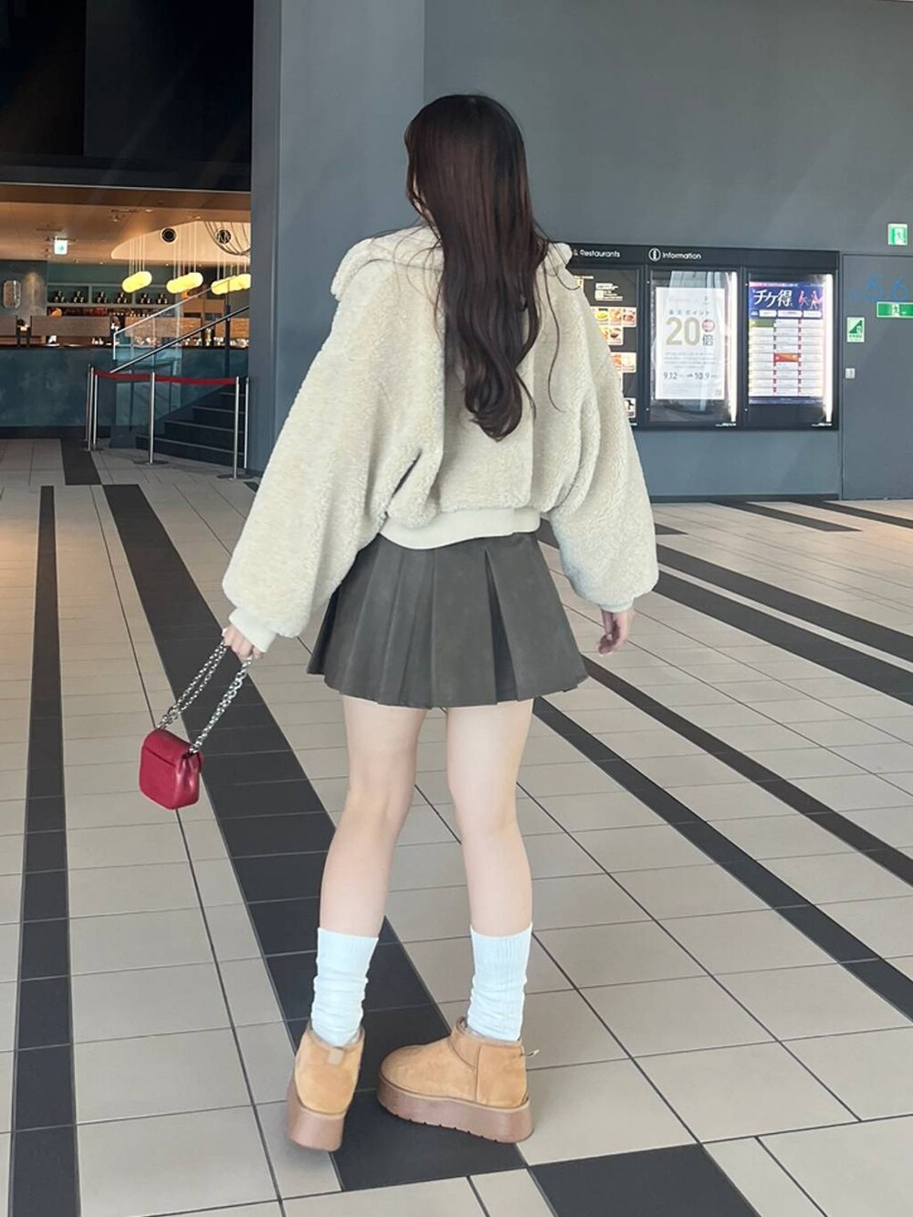ホワイト系のTシャツ/カットソー、ホワイト系のカーディガン/ボレロ、ベージュ系のブーツを着用したレディースの冬コーディネートの3枚目の写真
