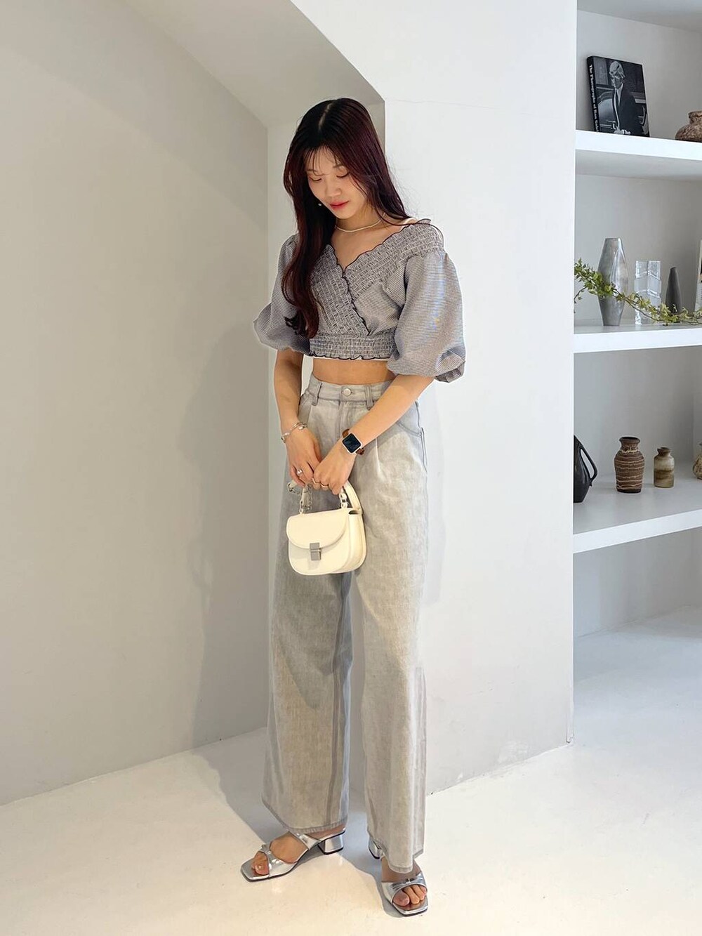 シルバー系のサンダル、ホワイト系のキャミソール、グレー系のデニムパンツを着用したレディースの春コーディネートの6枚目の写真