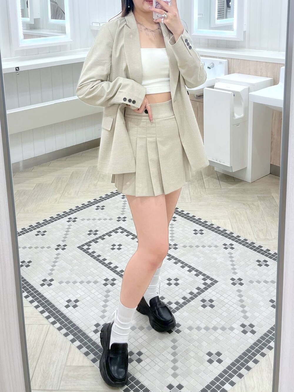 ホワイト系のキャミソール、ブラック系のローファー、ベージュ系のスカートを着用したレディースの春コーディネートの4枚目の写真