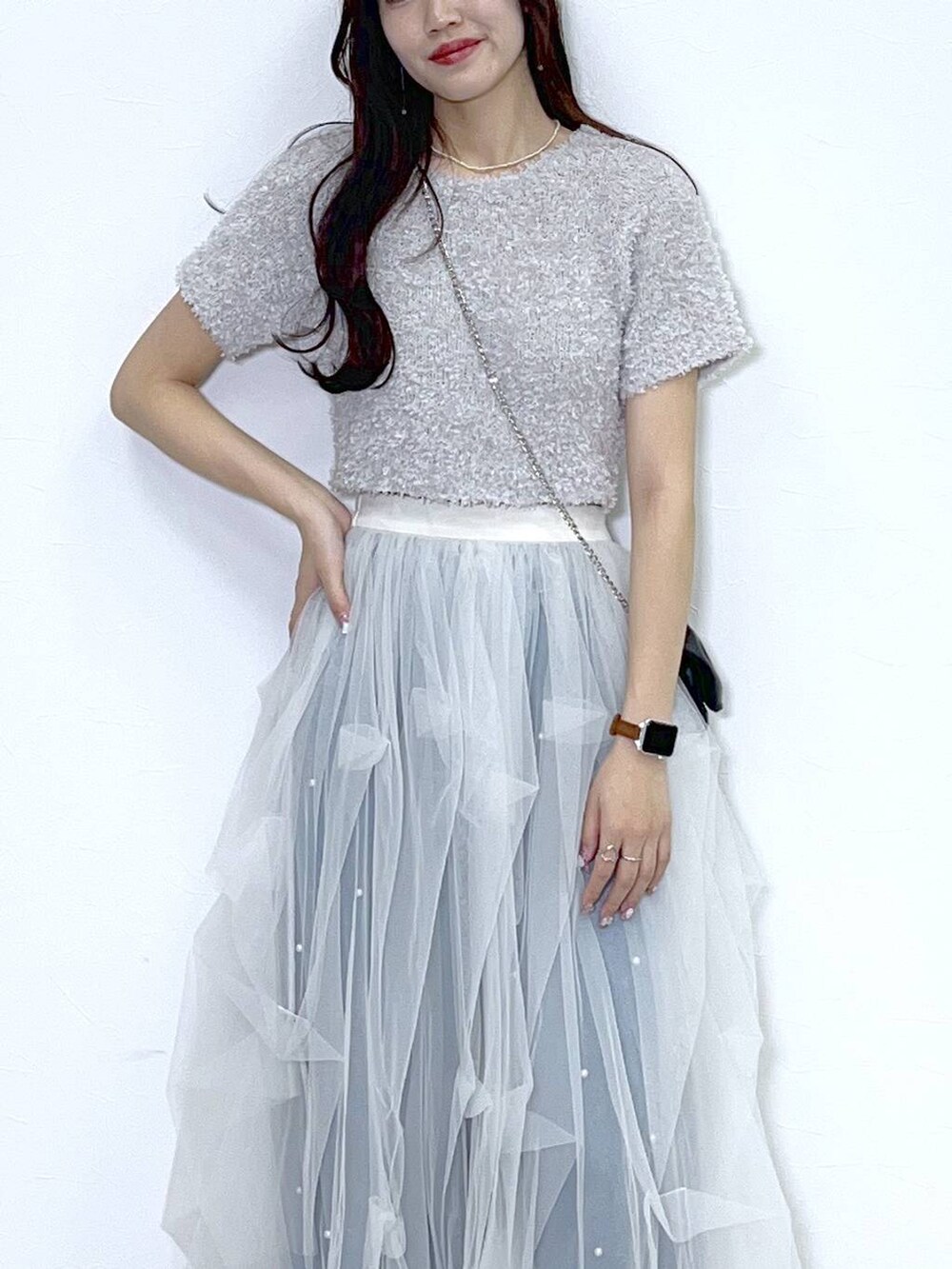 ブラック系のショルダーバッグ、ブルー系のデニムパンツ、ホワイト系のキャミソールを着用したレディースの春コーディネートの6枚目の写真