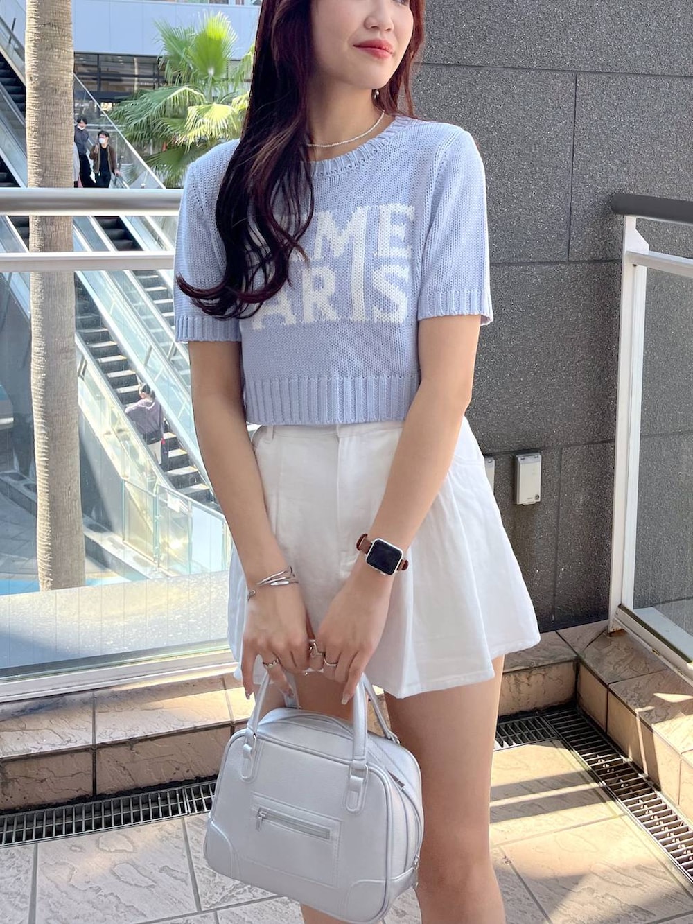 ブルー系のニット/セーター、ホワイト系のキャミソール、ブラック系のサンダルを着用したレディースの夏コーディネートの7枚目の写真