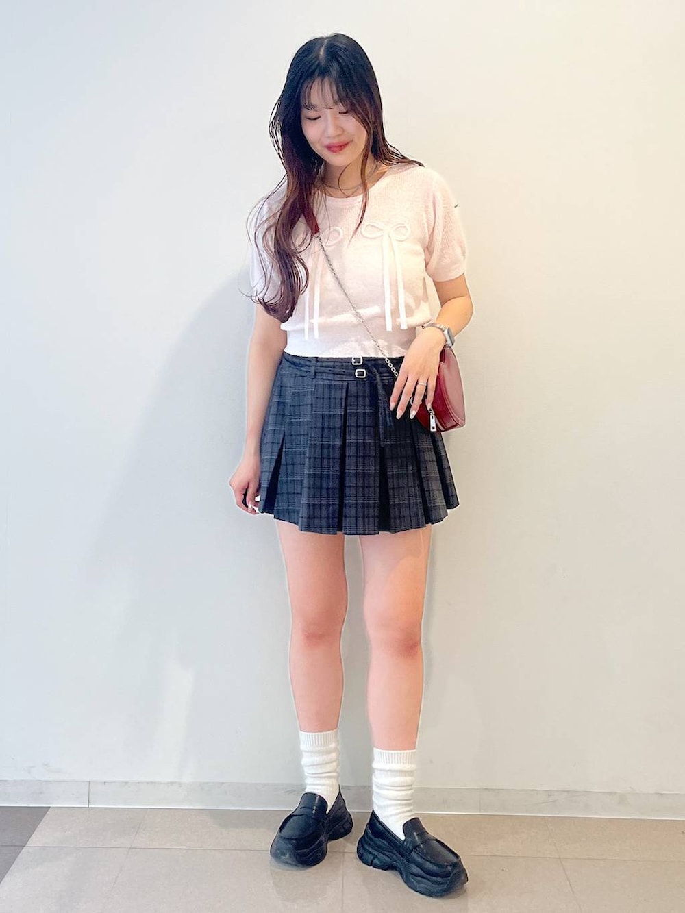 ホワイト系のキャミソール、ブラック系のローファー、グレー系のスカートを着用したレディースの春コーディネートの7枚目の写真