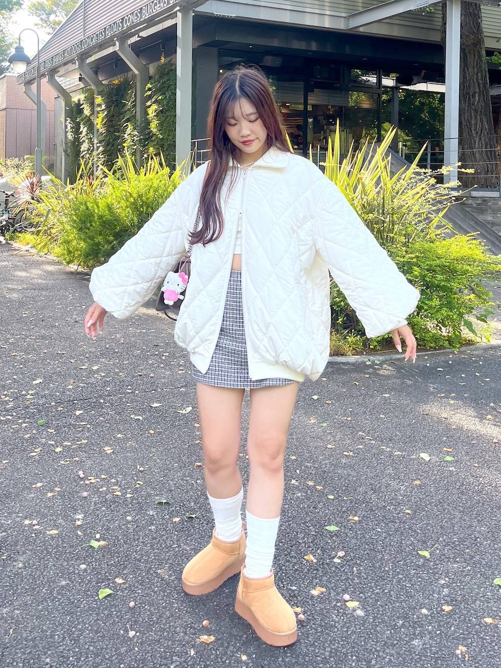 ブラウン系のショルダーバッグ、ホワイト系のTシャツ/カットソー、ベージュ系のブーツを着用したレディースの秋コーディネートの4枚目の写真