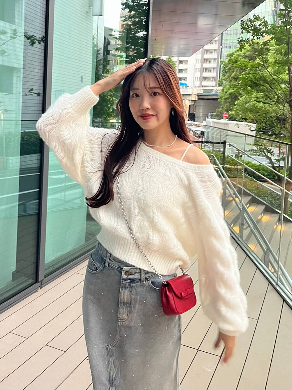 ブルー系のデニムスカート、ホワイト系のキャミソール、レッド系のショルダーバッグを着用したレディースの秋コーディネートの7枚目の写真