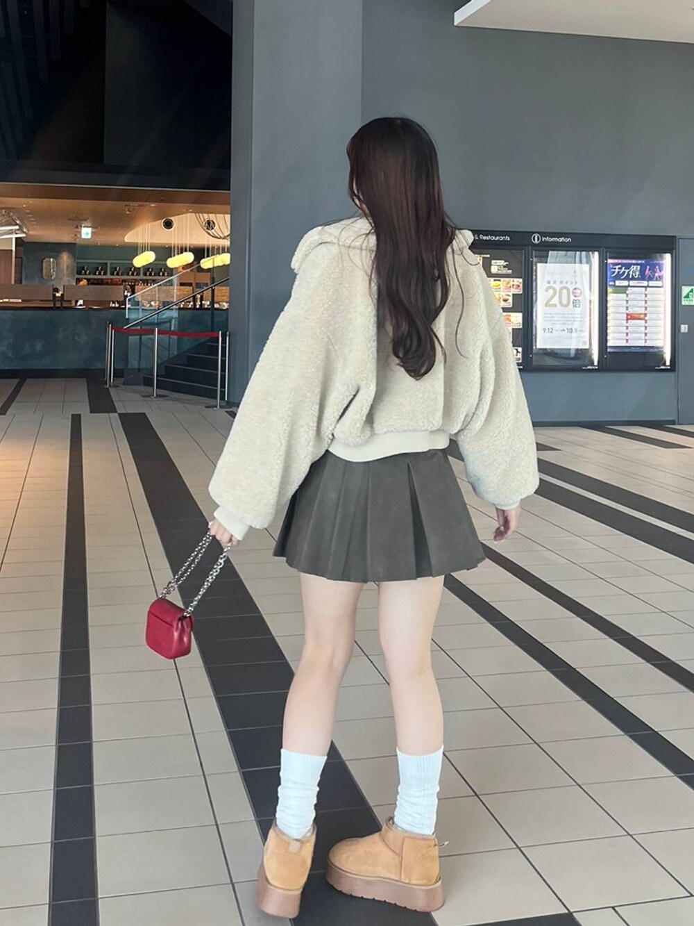 ホワイト系のTシャツ/カットソー、ホワイト系のカーディガン/ボレロ、ベージュ系のブーツを着用したレディースの冬コーディネートの10枚目の写真