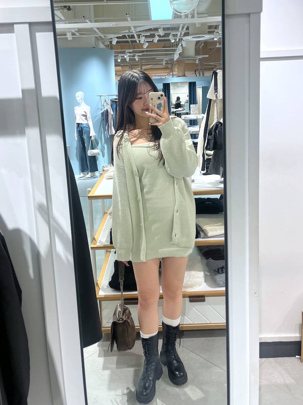 ブラック系のショルダーバッグ、ブラック系のブーツ、ホワイト系のTシャツ/カットソーを着用したレディースの冬コーディネートの4枚目の写真