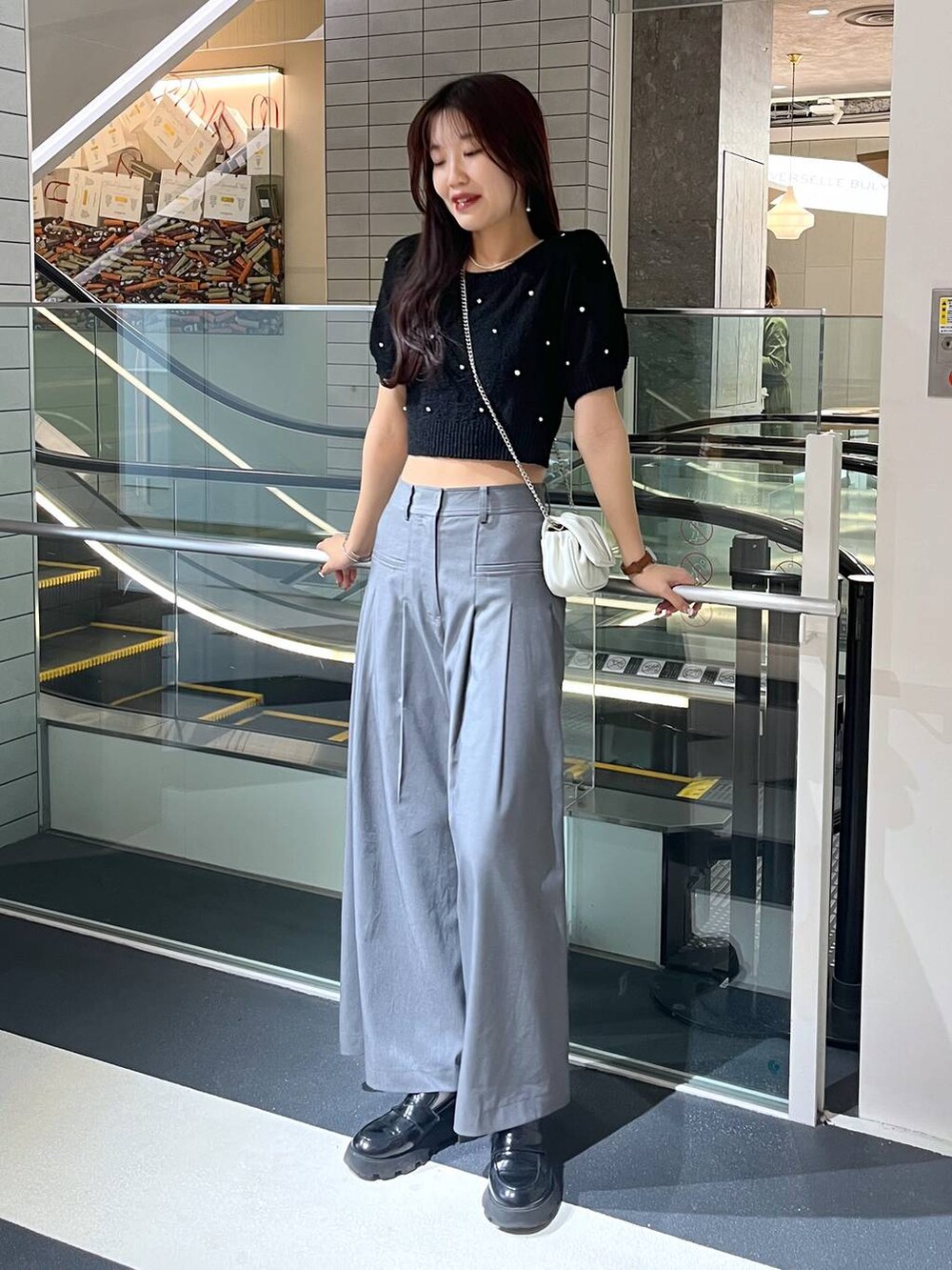 ホワイト系のショルダーバッグ、ホワイト系のキャミソール、ブラック系のローファーを着用したレディースの春コーディネートの3枚目の写真