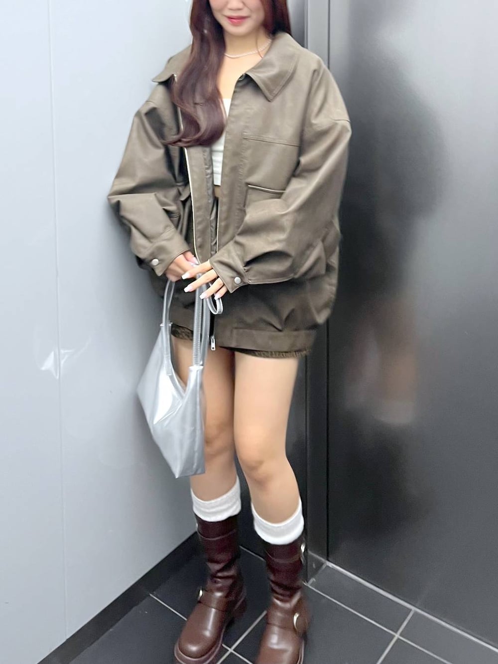 ブラウン系のブーツ、その他のスカート、ホワイト系のキャミソールを着用したレディースの秋コーディネートの2枚目の写真