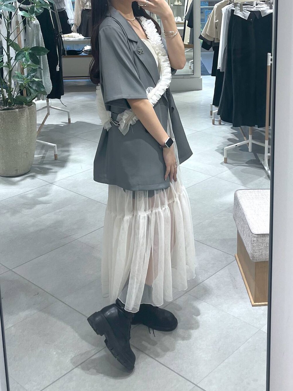 ホワイト系のワンピース、ホワイト系のキャミソール、ブラック系のブーツを着用したレディースの春コーディネートの4枚目の写真