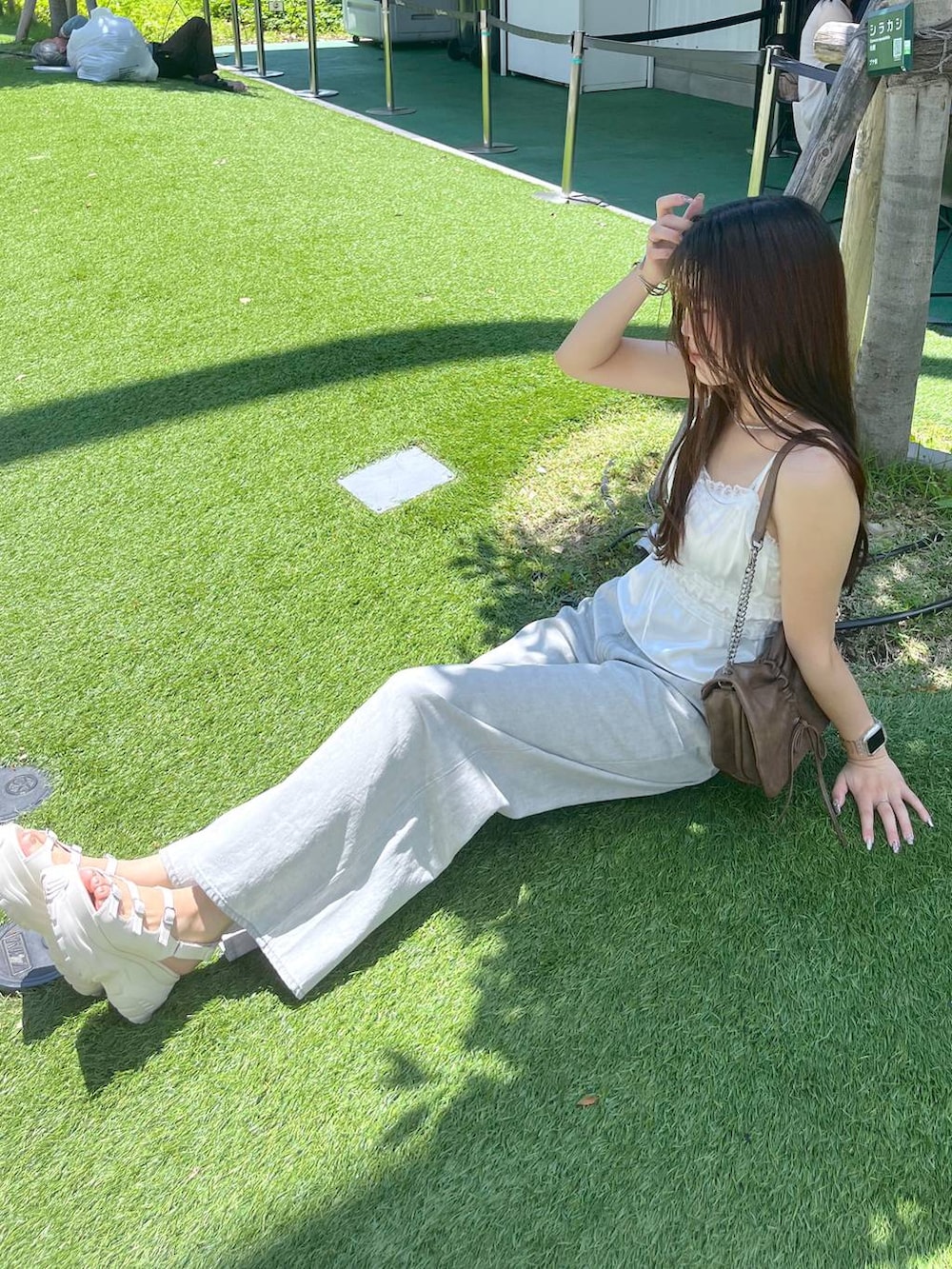ホワイト系のキャミソール、グレー系のデニムパンツ、ホワイト系のサンダルを着用したレディースの夏コーディネートの3枚目の写真