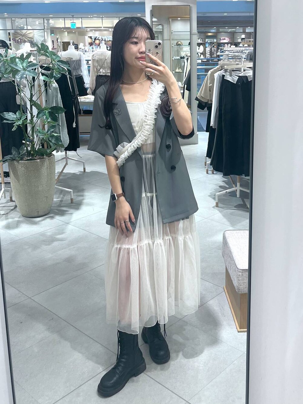 ホワイト系のワンピース、ホワイト系のキャミソール、ブラック系のブーツを着用したレディースの春コーディネートの5枚目の写真