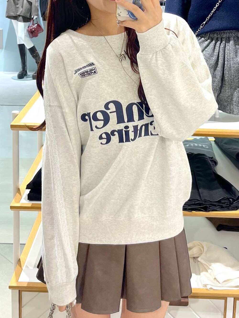 ホワイト系のTシャツ/カットソー、ブラウン系のスカート、ベージュ系のブーツを着用したレディースの秋コーディネートの9枚目の写真