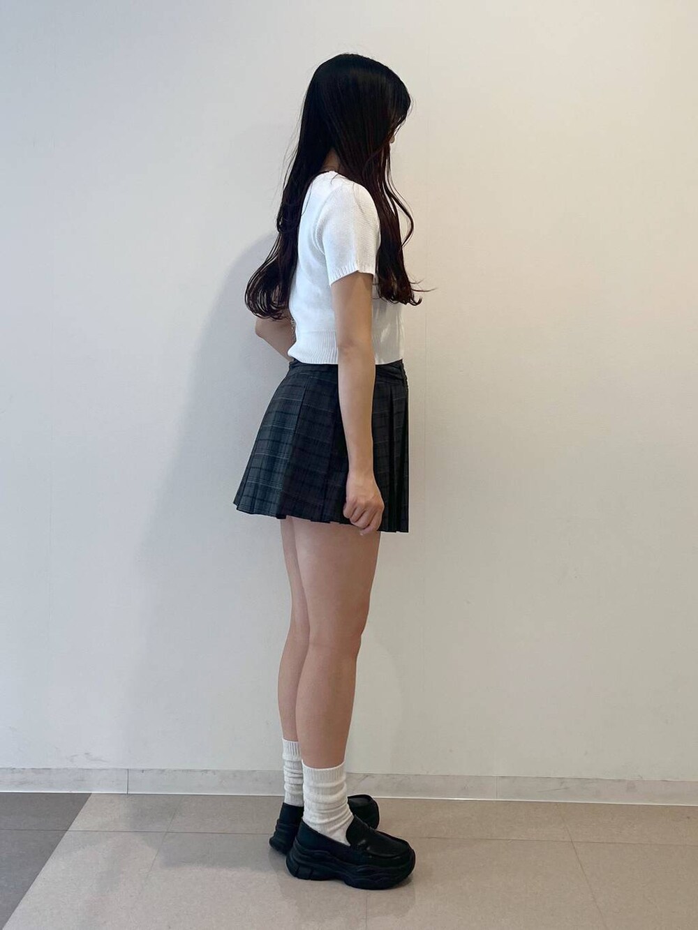 ホワイト系のキャミソール、ブラック系のローファー、グレー系のスカートを着用したレディースの夏コーディネートの5枚目の写真