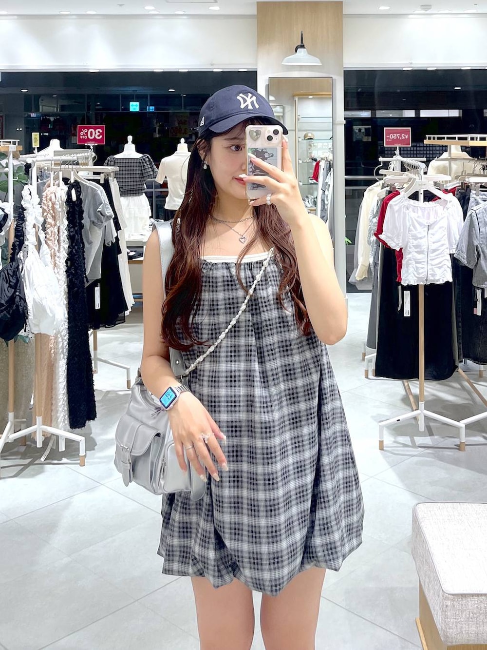 ブラック系のスニーカー、ホワイト系のキャミソール、シルバー系のショルダーバッグを着用したレディースの夏コーディネートの2枚目の写真