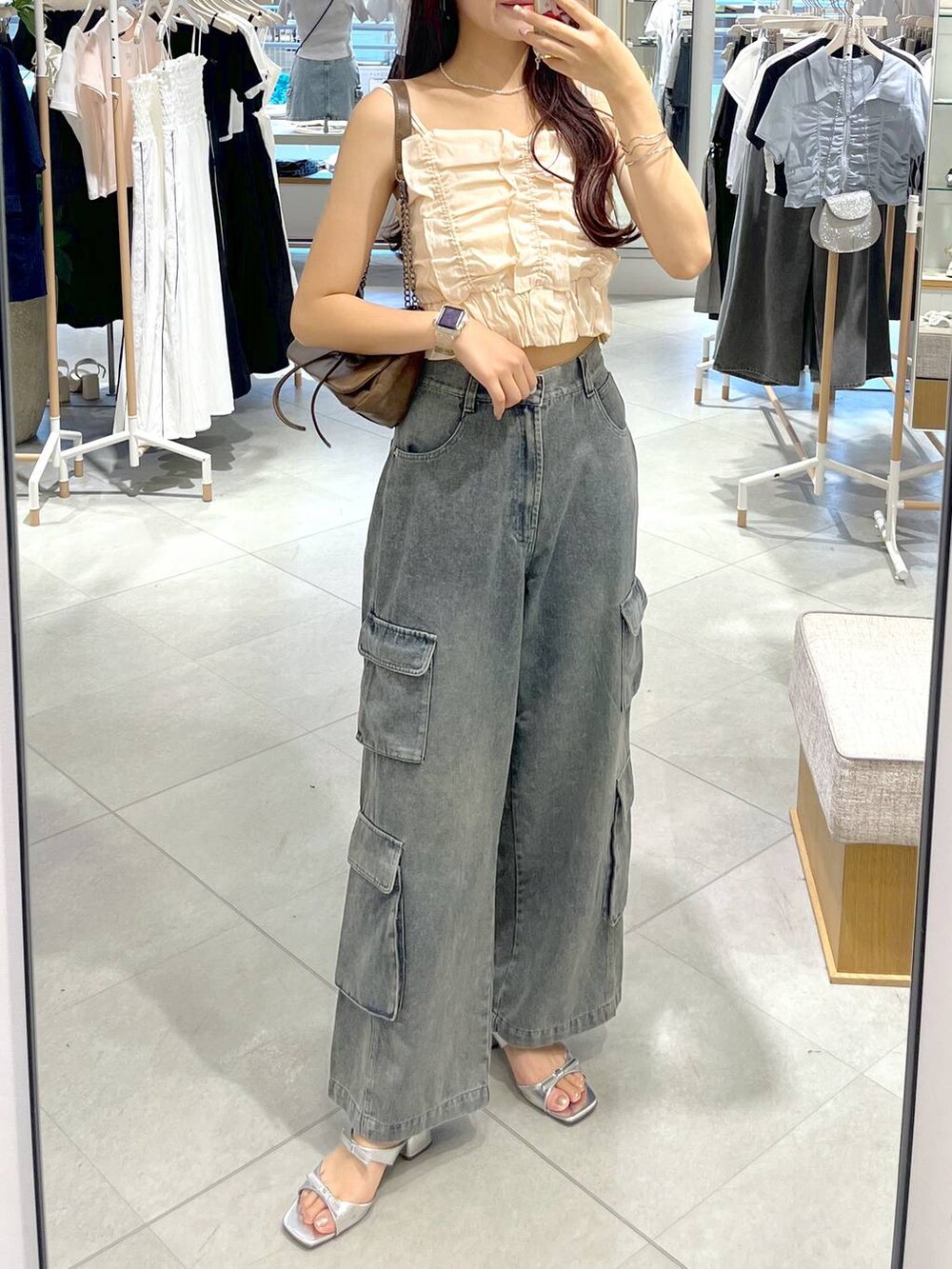 シルバー系のサンダル、ホワイト系のキャミソール、ブルー系のデニムパンツを着用したレディースの夏コーディネートの3枚目の写真