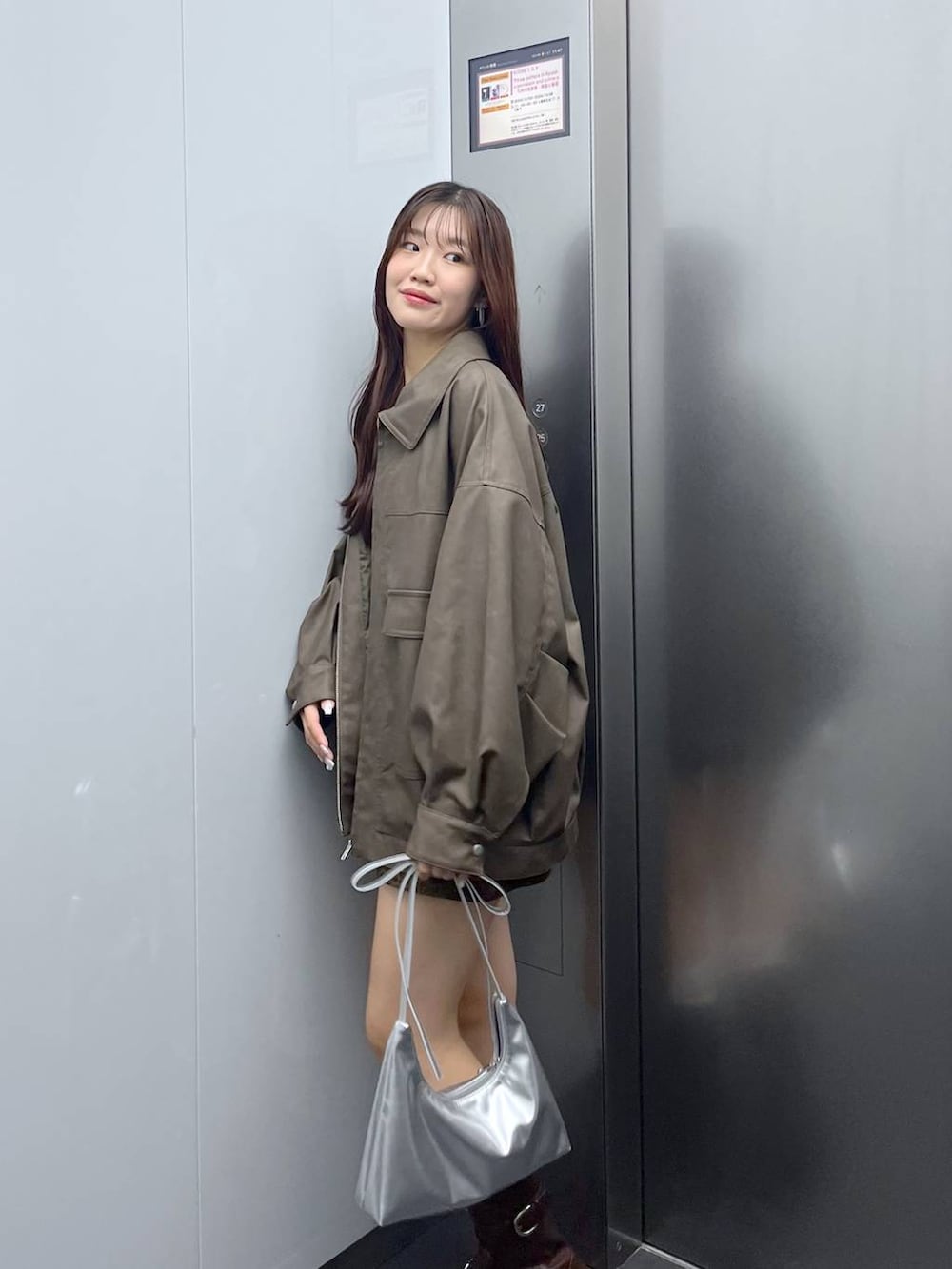 ブラウン系のブーツ、その他のスカート、シルバー系のショルダーバッグを着用したレディースの秋コーディネートの4枚目の写真