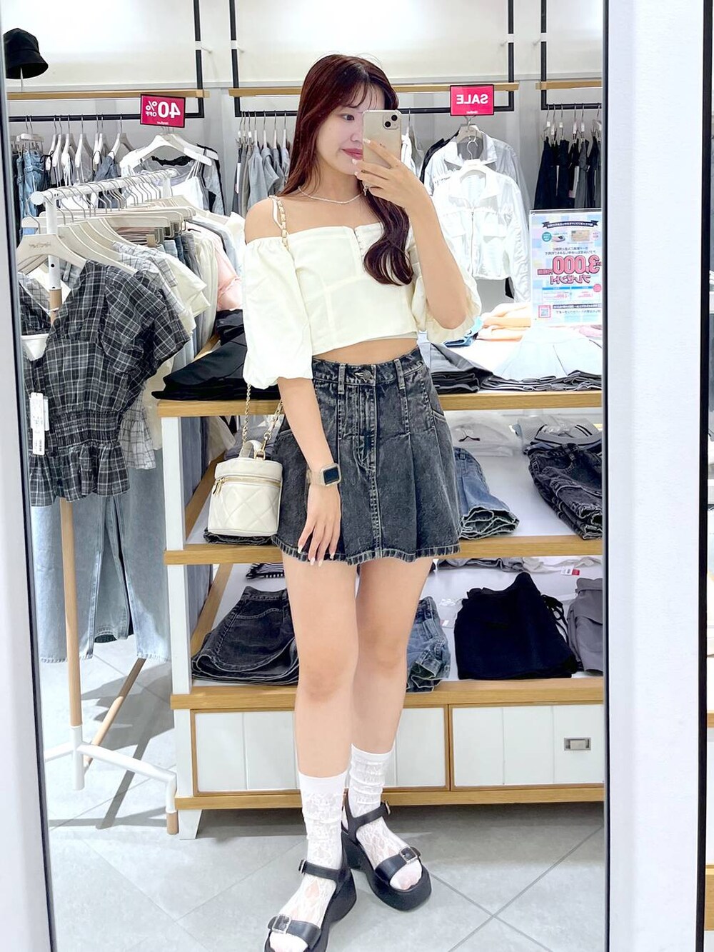 ブラック系のデニムスカート、ブラック系のサンダル、ホワイト系のショルダーバッグを着用したレディースの夏コーディネートの10枚目の写真