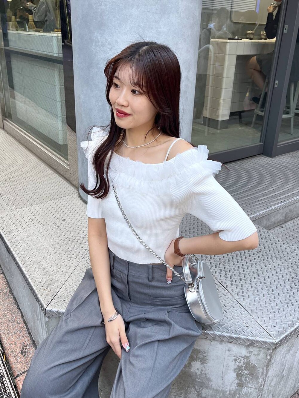 シルバー系のショルダーバッグ、グレー系のスラックス、ホワイト系のキャミソールを着用したレディースの春コーディネートの5枚目の写真