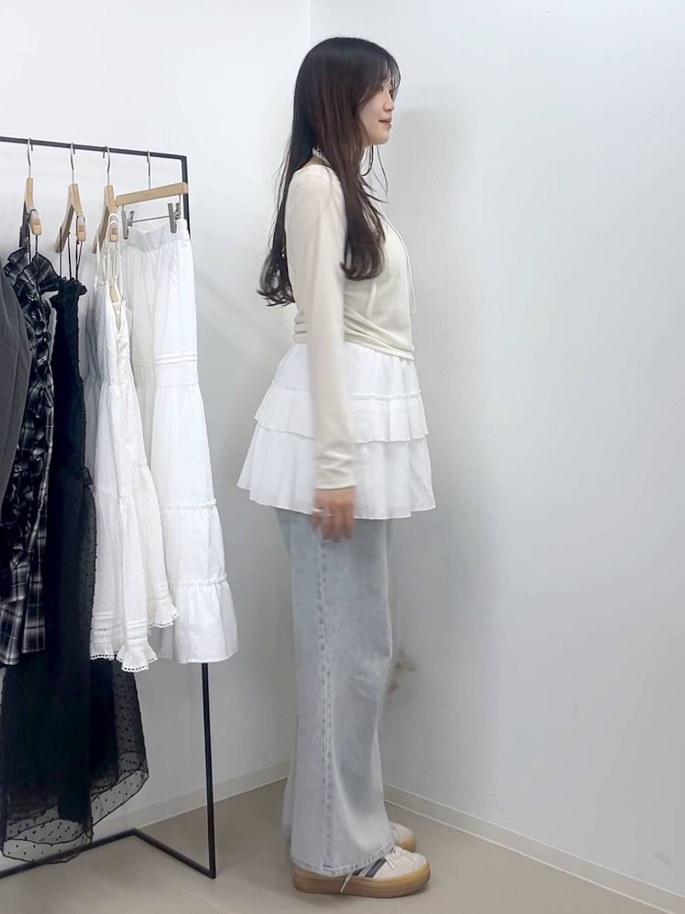 ホワイト系のキャミソール、ブルー系のデニムパンツ、ホワイト系のスカートを着用したレディースの春コーディネートの3枚目の写真