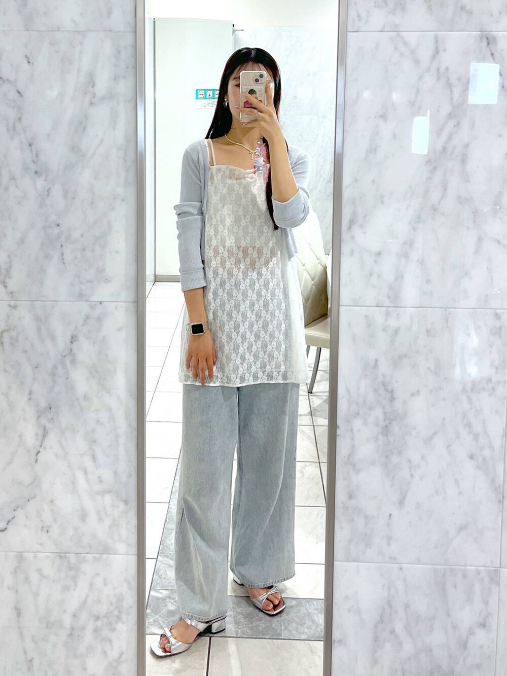 シルバー系のサンダル、ブルー系のカーディガン/ボレロ、ホワイト系のキャミソールを着用したレディースの春コーディネートの2枚目の写真