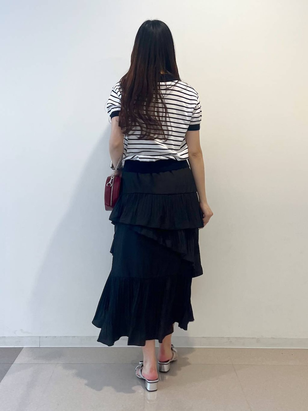 ホワイト系のキャミソール、ブラック系のスカート、シルバー系のサンダルを着用したレディースの春コーディネートの4枚目の写真