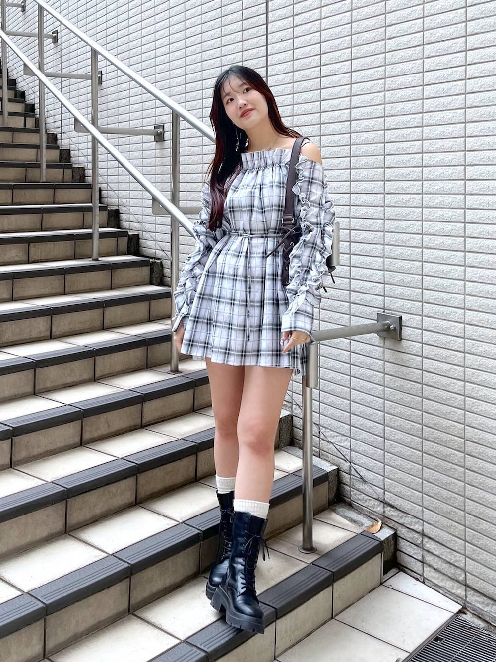 ホワイト系のキャミソール、ブラック系のデニムスカート、ブラウン系のショルダーバッグを着用したレディースの春コーディネートの7枚目の写真