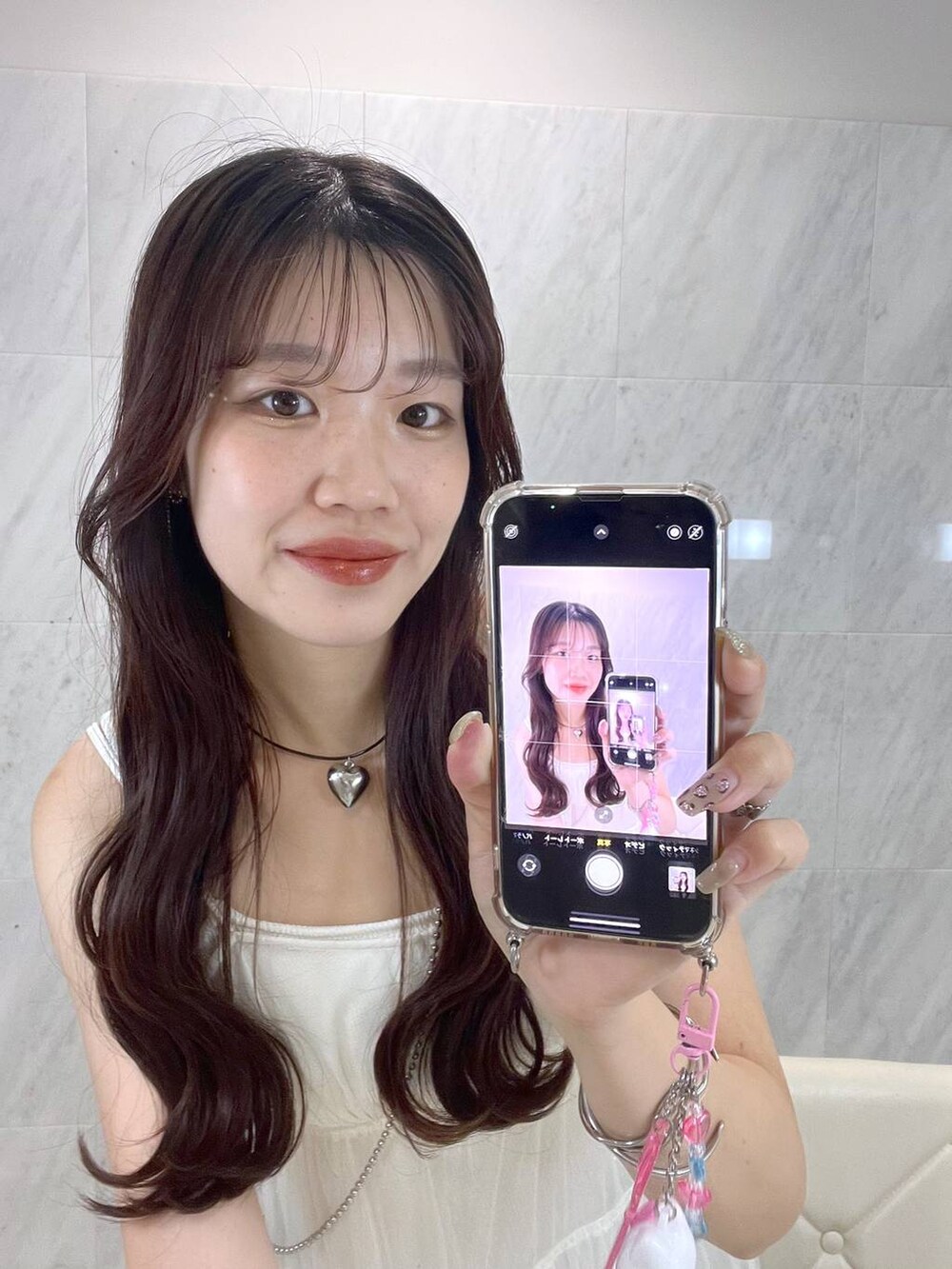 ホワイト系のワンピース、シルバー系のサンダル、ホワイト系のキャミソールを着用したレディースの夏コーディネートの5枚目の写真