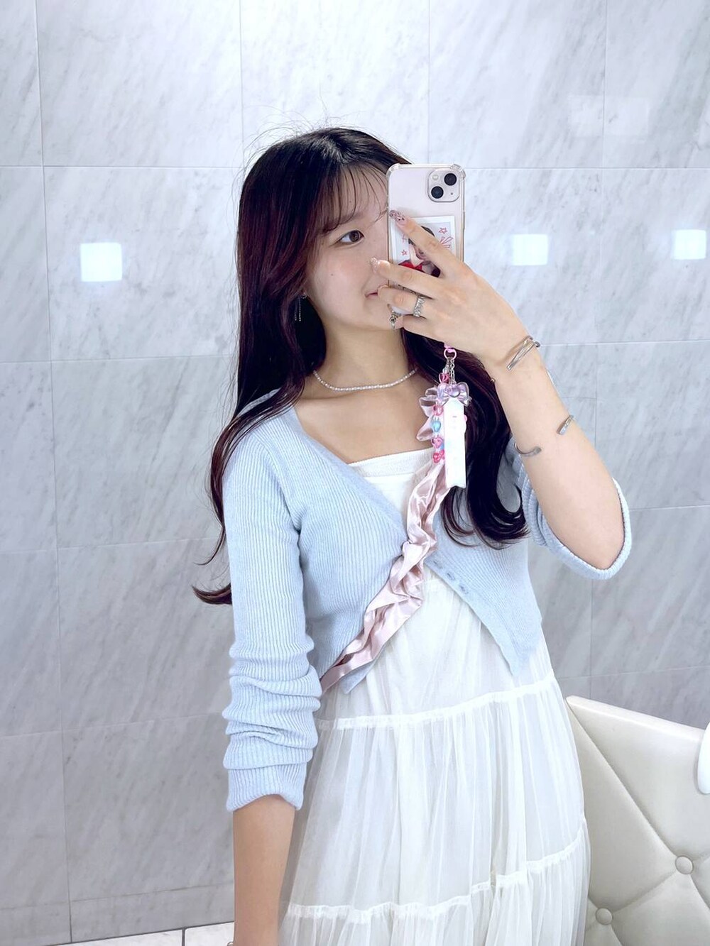 ピンク系のショルダーバッグ、ホワイト系のキャミソール、ブルー系のデニムパンツを着用したレディースの夏コーディネートの2枚目の写真