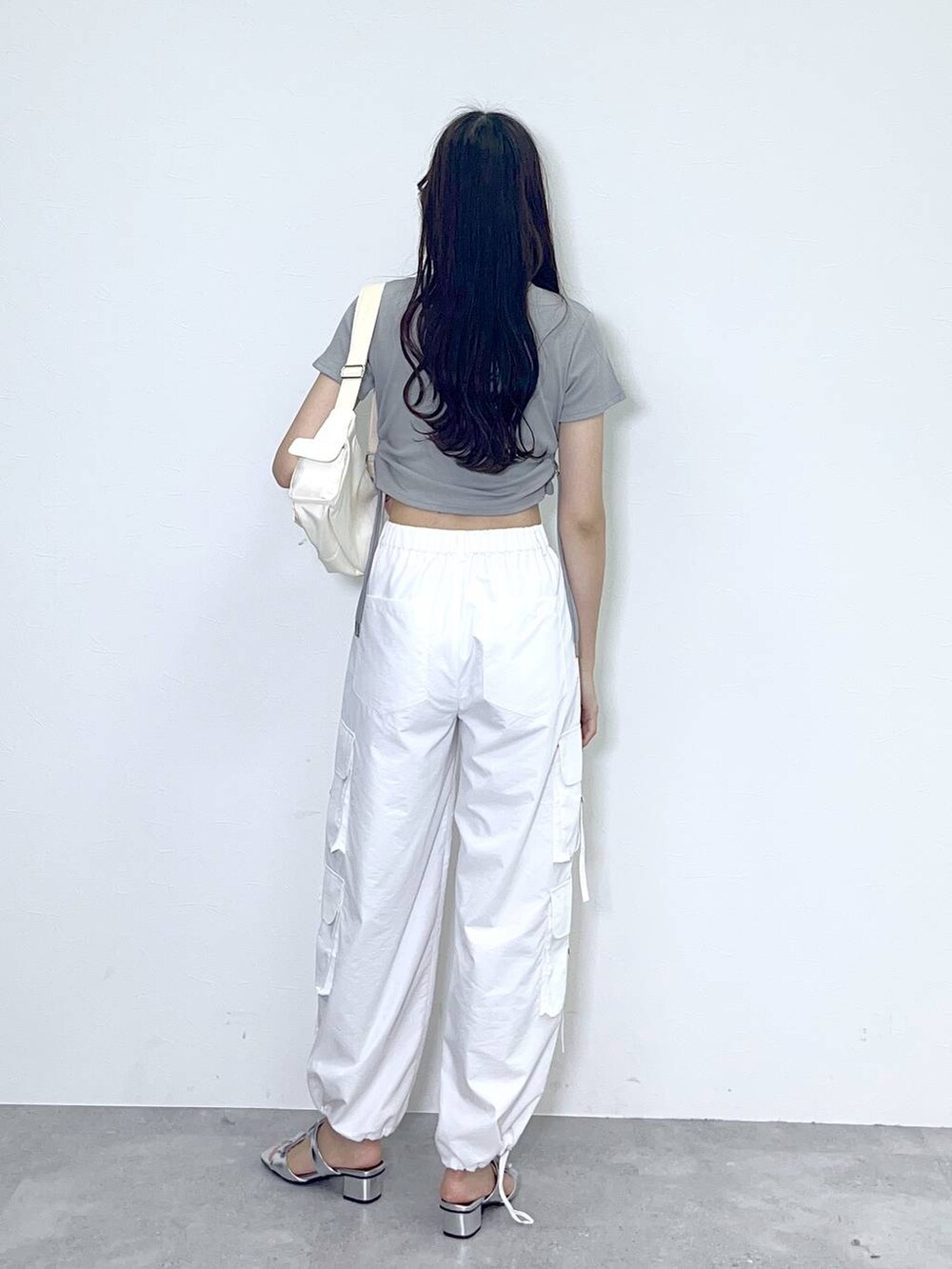 ホワイト系のショルダーバッグ、ホワイト系のカーゴパンツ、シルバー系のサンダルを着用したレディースの春コーディネートの3枚目の写真