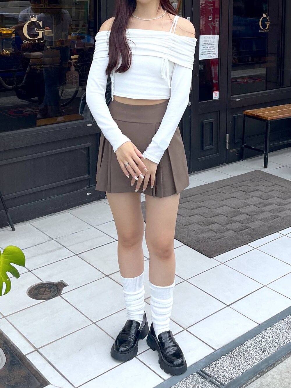 ブラウン系のスカート、グレー系のショルダーバッグ、ホワイト系のキャミソールを着用したレディースの秋コーディネートの5枚目の写真