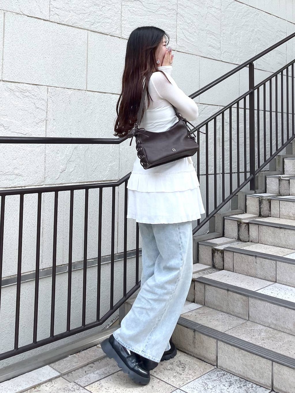 ブルー系のデニムパンツ、ホワイト系のキャミソール、ホワイト系のスカートを着用したレディースの春コーディネートの6枚目の写真
