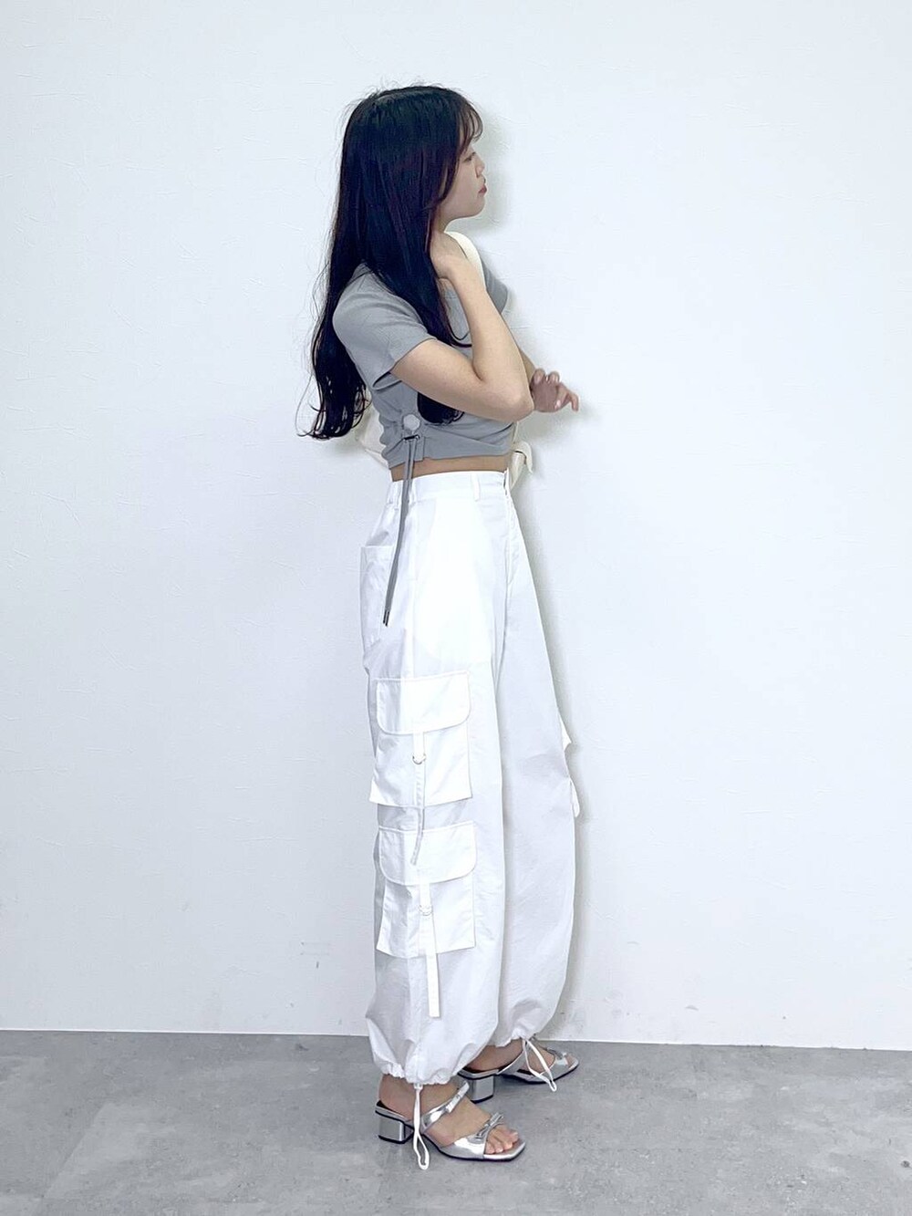 ホワイト系のショルダーバッグ、ホワイト系のカーゴパンツ、シルバー系のサンダルを着用したレディースの春コーディネートの4枚目の写真