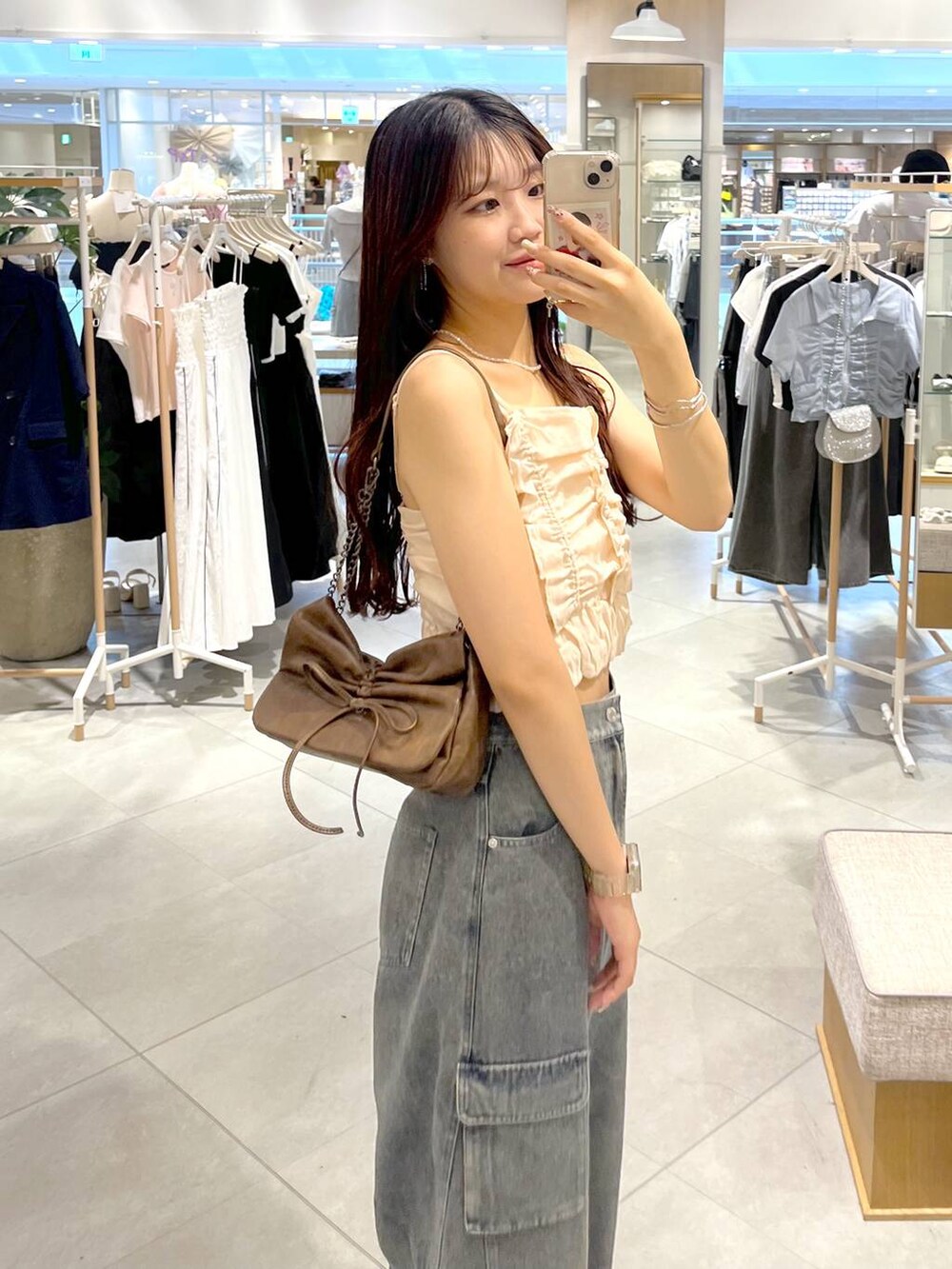 シルバー系のサンダル、ホワイト系のキャミソール、ブルー系のデニムパンツを着用したレディースの夏コーディネートの8枚目の写真