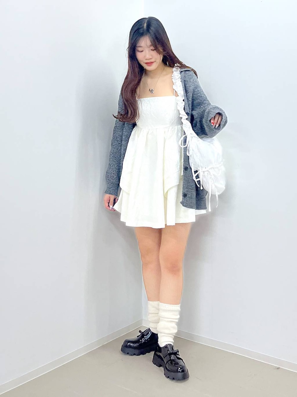 ブラック系のドレスシューズ、ホワイト系のワンピース、ホワイト系のショルダーバッグを着用したレディースの春コーディネートの6枚目の写真