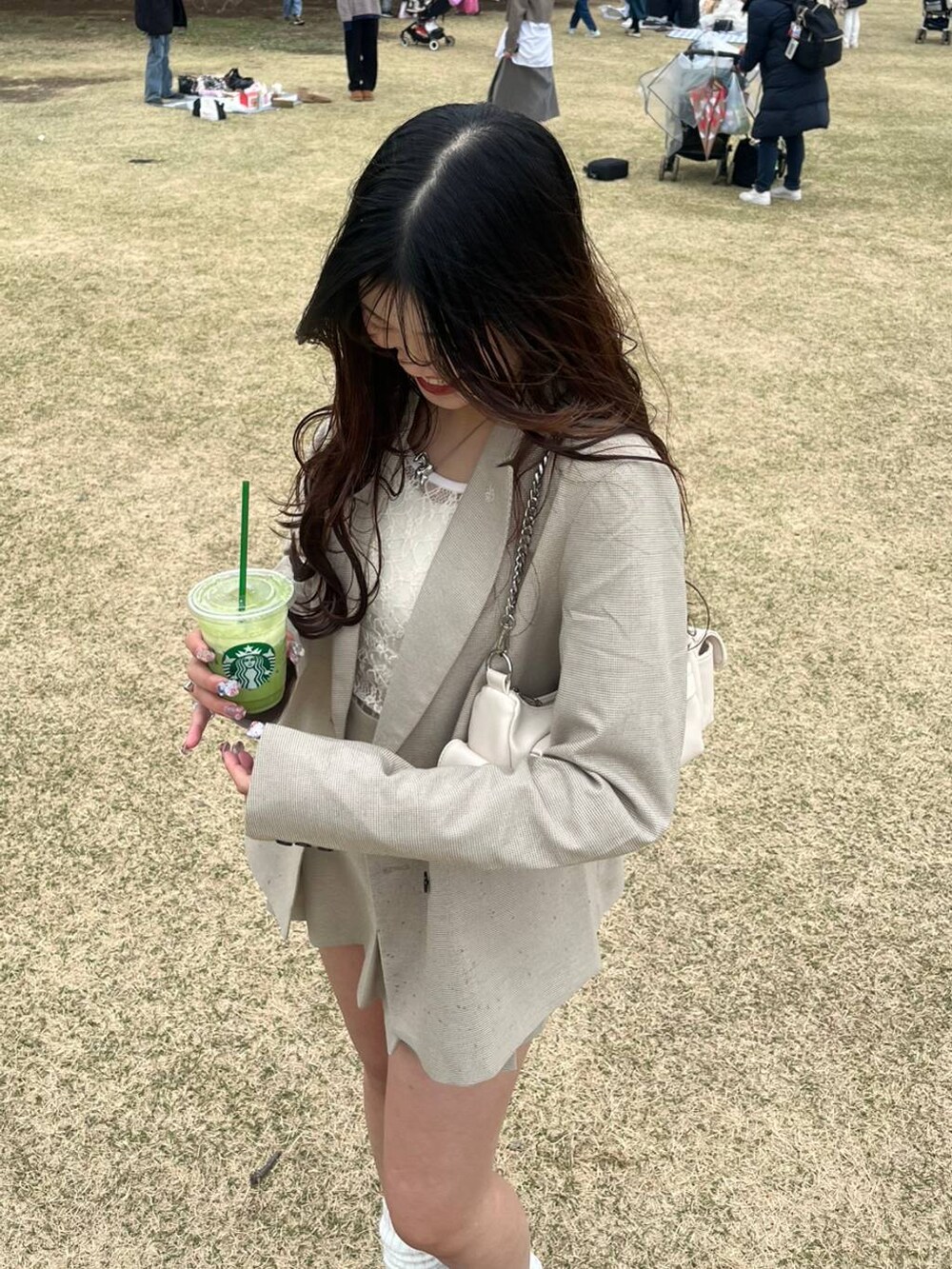 ホワイト系のキャミソール、ベージュ系のスカート、シルバー系のネックレスを着用したレディースの春コーディネートの5枚目の写真