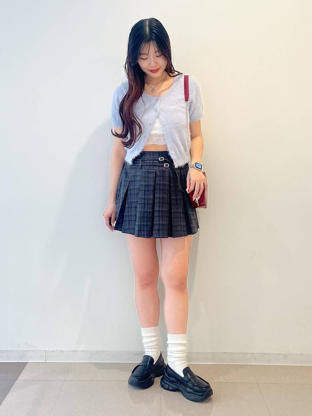 ブラック系のローファー、グレー系のスカート、レッド系のショルダーバッグを着用したレディースの春コーディネートの7枚目の写真